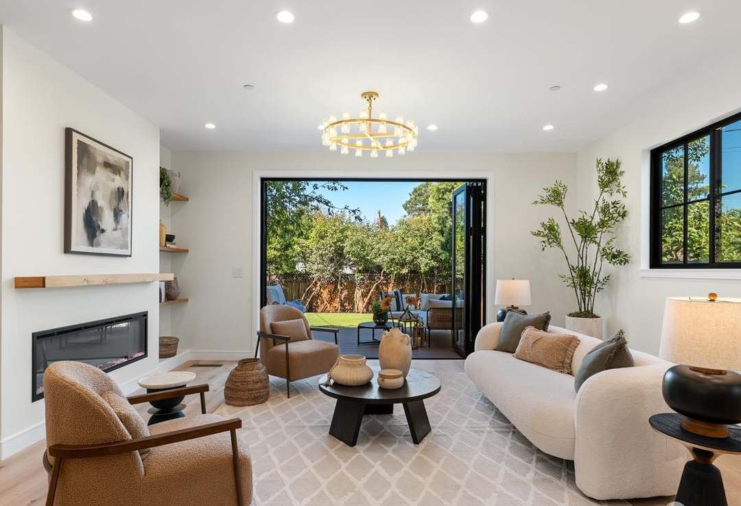 Living room with linear fireplace and folding glass wall open to the yard